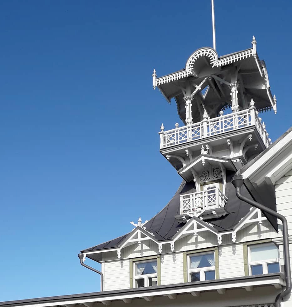 Villa Hannalan yläkerta ja torni sinistä taivasta vasten.